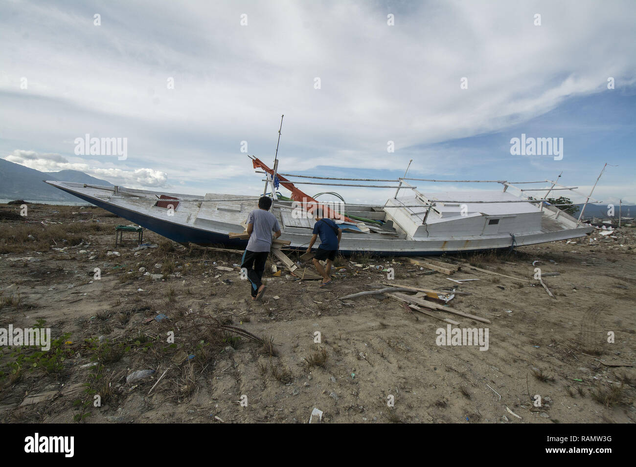 Palu, Indonesien. 04 Jan, 2019. Die Bewohner nehmen den Rest des Holzes in der ehemaligen Lage der tsunami Hauptgewicht auf talise Strand, Palu Bay, Zentral Sulawesi, Indonesien, Freitag (01/02/2019). Erst mehr als drei Monate nach dem Tsunami, die Anzahl der bisher eingeschlossenen Gebiete nicht aufgrund begrenzter Ausrüstung gelöscht. Der Tsunami, der am 28. September 2018 schlug ergab mehr als 2.000 Menschen getötet und mehr als 70.000 Vertriebene. Credit: bmzIMAGES/Alamy leben Nachrichten Stockfoto