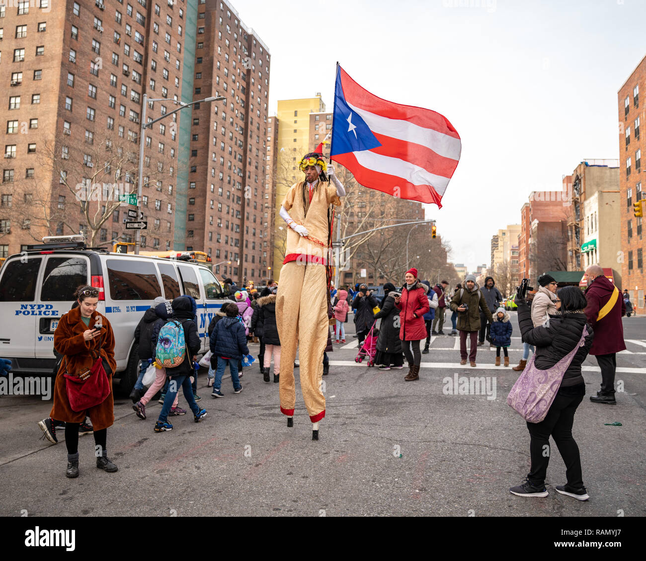 New York, USA. Am 4. Januar 2019. Ein Interpret auf Stelzen Wellen eine Flagge von Puerto Rico als er grüßt die Teilnehmer während der 42. jährlichen Drei Könige Day Parade El Barrio (East Harlem, New York City), organisiert von El Museo del Barrio, das Ereignis feiert die populären Glauben, dass drei Weisen besucht Jesus. Credit: Enrique Ufer/Alamy leben Nachrichten Stockfoto