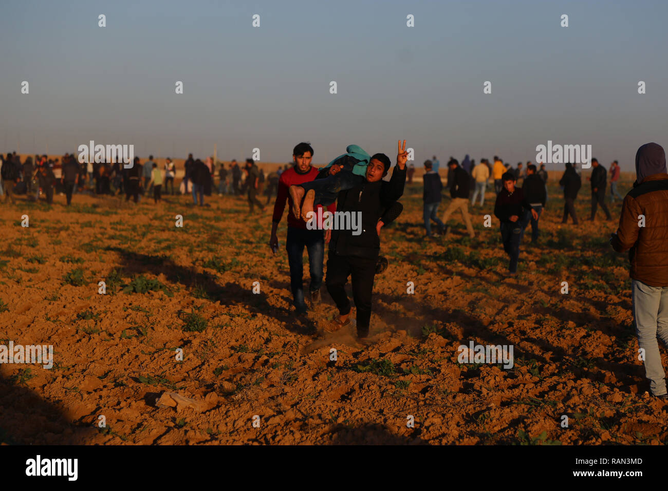 Eine Demonstrantin gesehen mit einem verletzten palästinensischen während der Auseinandersetzungen. Palästinenser mit israelischer Truppen stießen bei den Protesten auf der Gaza-Israel Wand östlich von Khan Yunis. Stockfoto