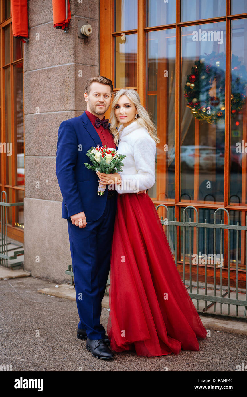 Eine schöne Frau in rotem Kleid steht mit einem Mann, Braut und Bräutigam,  glücklich verheiratet Stockfotografie - Alamy