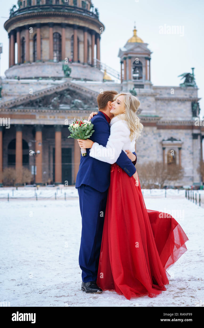 Schöne Frau im roten Kleid und Mann posiert im Winter, Hochzeit in St.  Petersburg Stockfotografie - Alamy