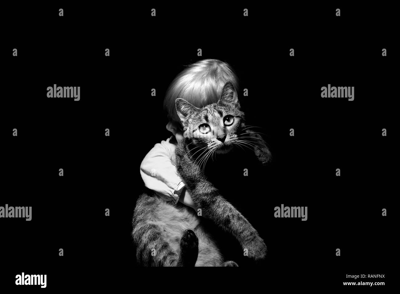 Ein kleines Mädchen ist herzlich umarmte ihre geliebten Haustier Katze. Die Schwarz-Weiß-Fotografie Stockfoto