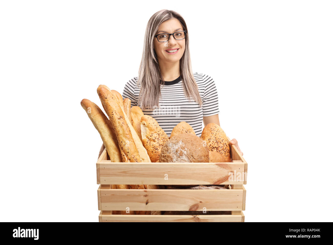 Lächelnde junge Frau mit einer Kiste voller Brot Laibe auf weißem Hintergrund Stockfoto