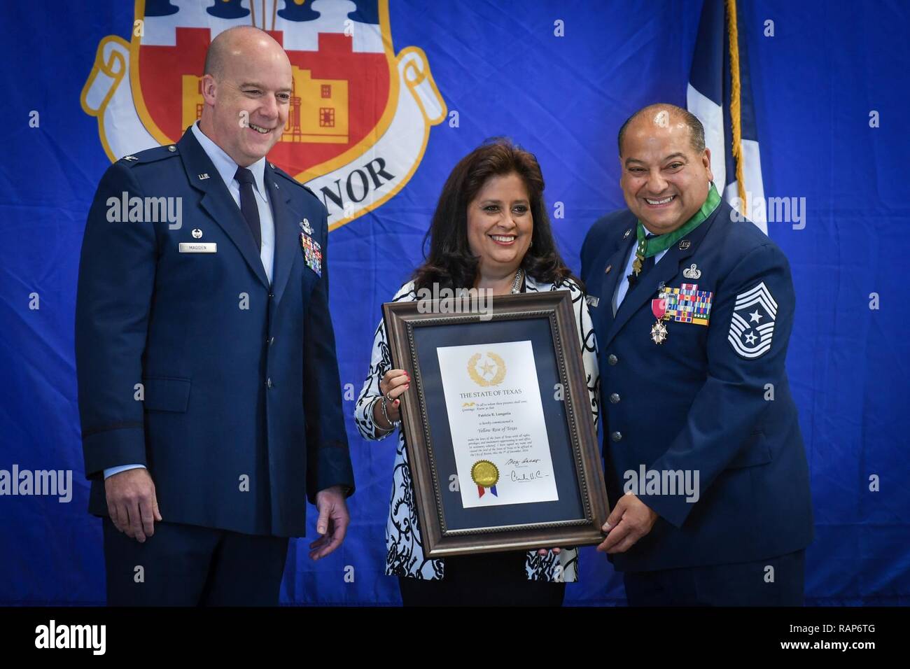 Command Chief Master Sgt. George B. Longoria (rechts) und seine Frau, Pastetchen, halten Sie ein Zertifikat von Texas reg. Greg Abbott Patty Ehrung als "Gelbe Rose von Texas" für ihre Unterstützung der Longoria während seiner militärischen Karriere bei Joint Base San Antonio-Lackland, Texas, Feb 25, 2017. Die longorias sind von Oberst Timothy Madden, der Kommandant der 149 Fighter Wing, Texas Air National Guard. Longoria zieht sich nach 35 Jahren Militärdienst. Stockfoto