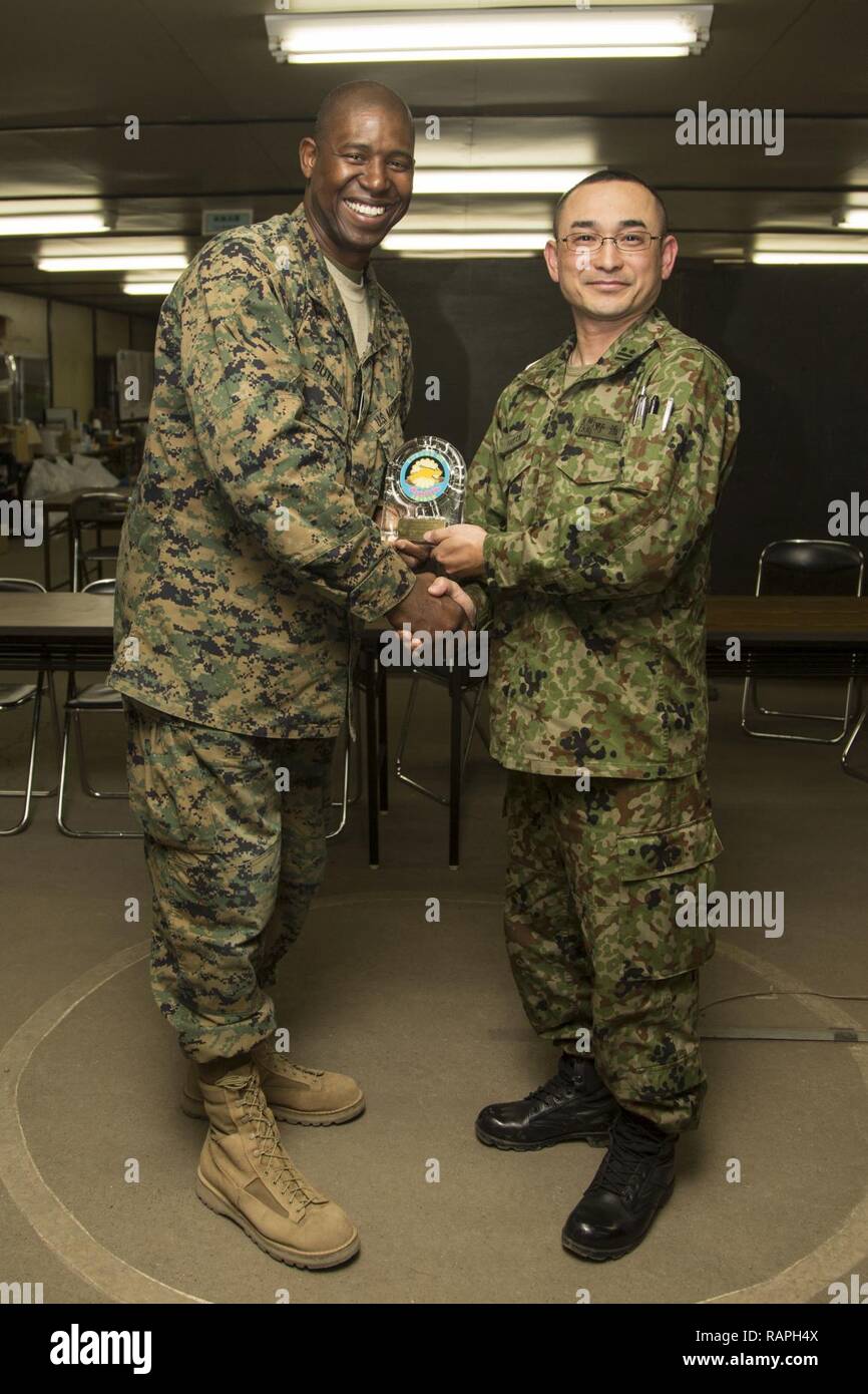 Us Marine Corps Oberstleutnant Brian Butler, ein Bataillon, kommandierender Offizier mit Sitz Batterie, 3.Bataillon, 12 Marines, posiert für ein Foto mit einem Service Mitglied der japanischen Boden Verteidigung-kraft nach Erhalt ein Geschenk innerhalb der bilateralen Koordination Zentrum im Hijudai Manöver, Japan, 3. März 2017. Marinesoldaten und Matrosen an der Artillerie relocation Training Programm rechtzeitige und genaue Brände zu stellen militärische beruflichen Spezialgebiet Fähigkeiten, Zug Marines/Matrosen in gemeinsamen Fähigkeiten zu unterstützen, und professionellen militärischen Ausbildung für das übergeordnete Ziel der Förderung Stockfoto