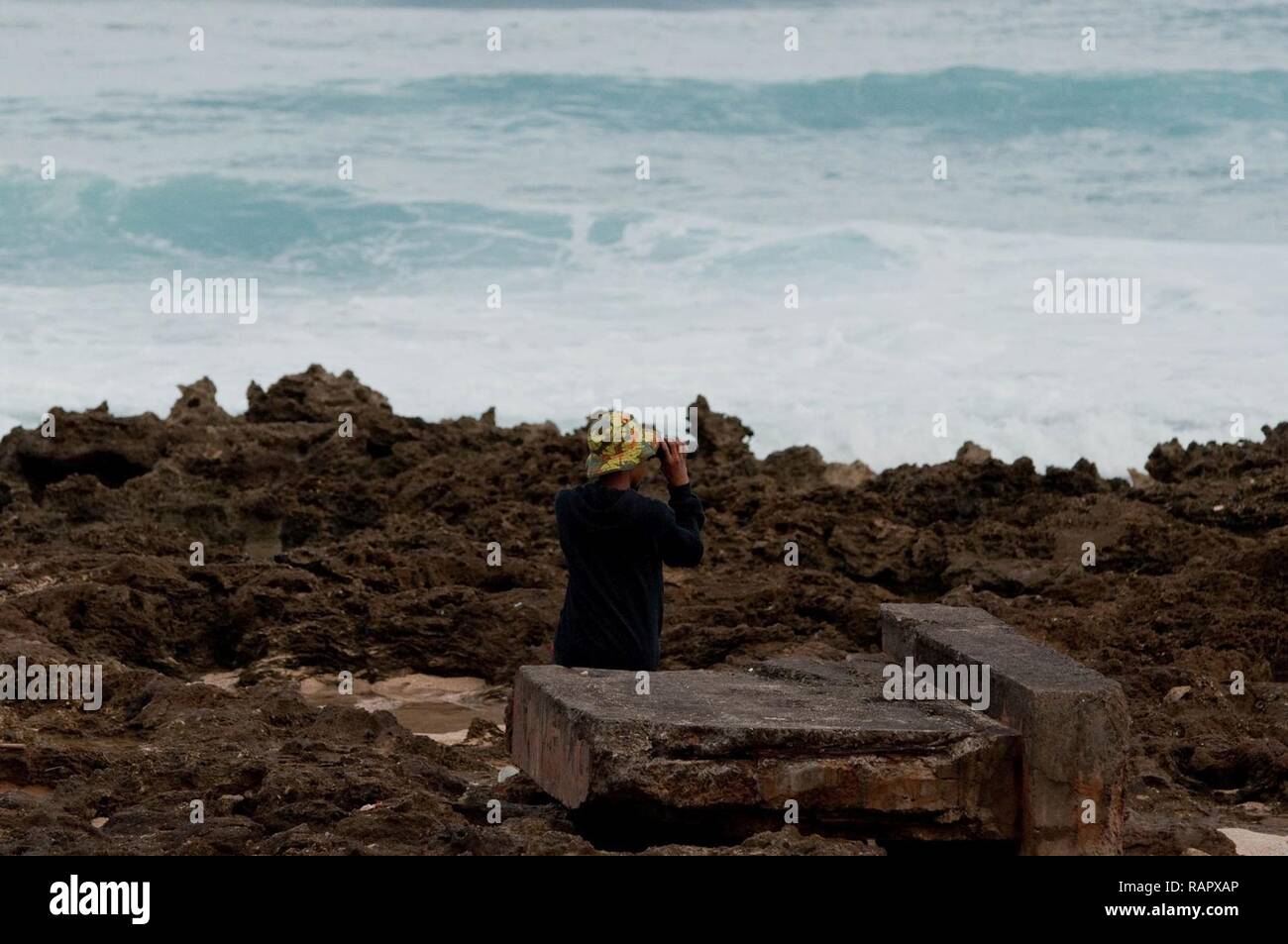 HALEIWA, Hawaii - Dashawn Terrell scannt den Horizont für die Buckelwale für die 2017 Sanctuary Ozean zählen Projekt bei Pua'ena, Jan. 25, 2017. Pua'ena Punkt ist einer der Standorte, an denen die freiwilligen Anschluss buckelwal Sichtungen. Das Heiligtum Ozean zählen tritt im Januar, Februar und März eines jeden Jahres und wird durch den hawaiischen Inseln Buckelwal National Marine Sanctuary koordiniert. Gebietsansässige und Gebietsfremde in der Zählung teil als Freiwilliger oder Site Leader. Stockfoto