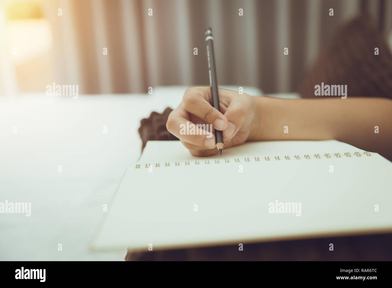 Student Hand halten Bleistift schreiben Hinweis Leerbuch vintage colortone Stockfoto