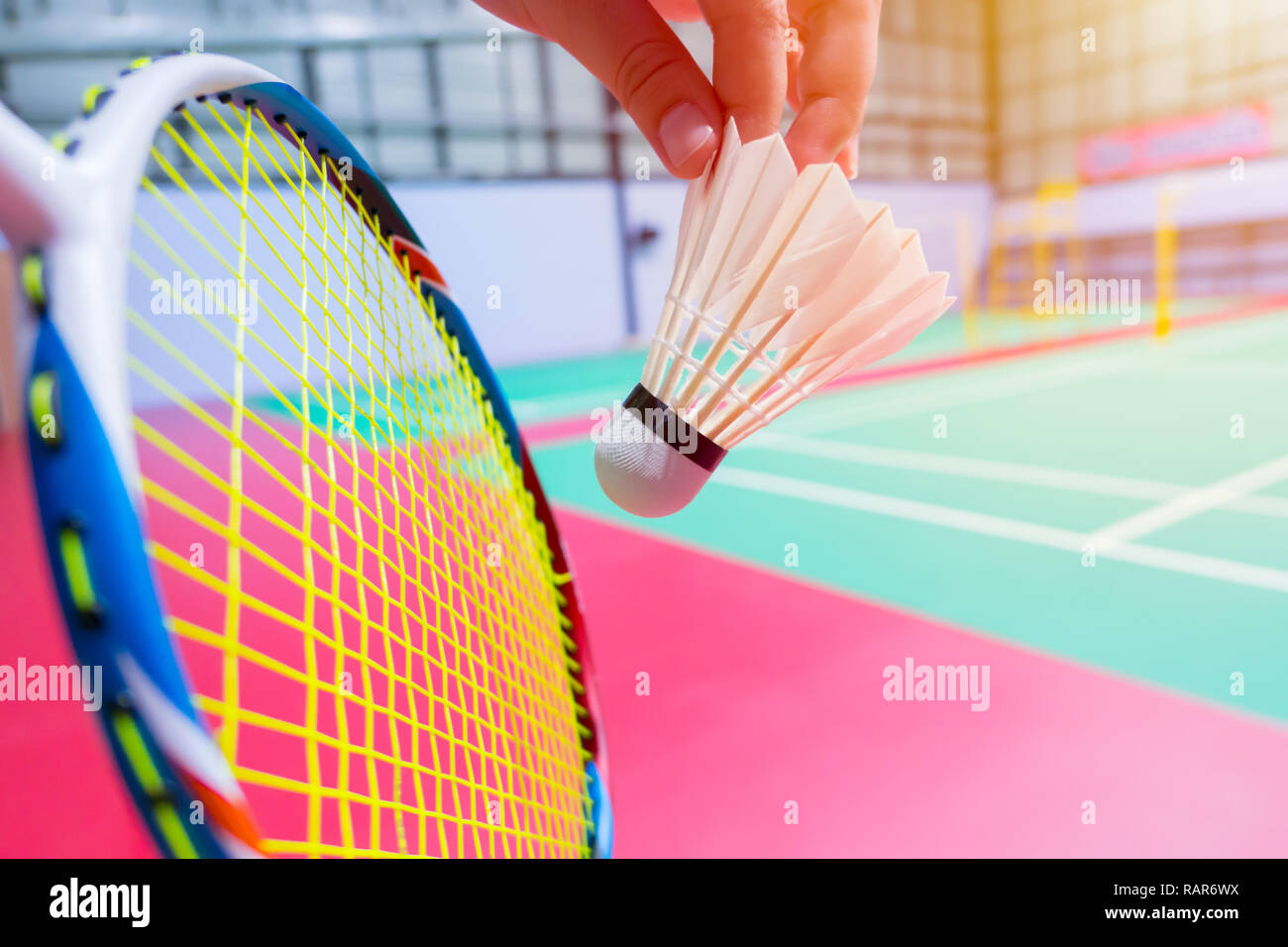 Nahaufnahme der Hand halten dienen Badminton Federball mit blur Badminton Hintergrund Stockfoto