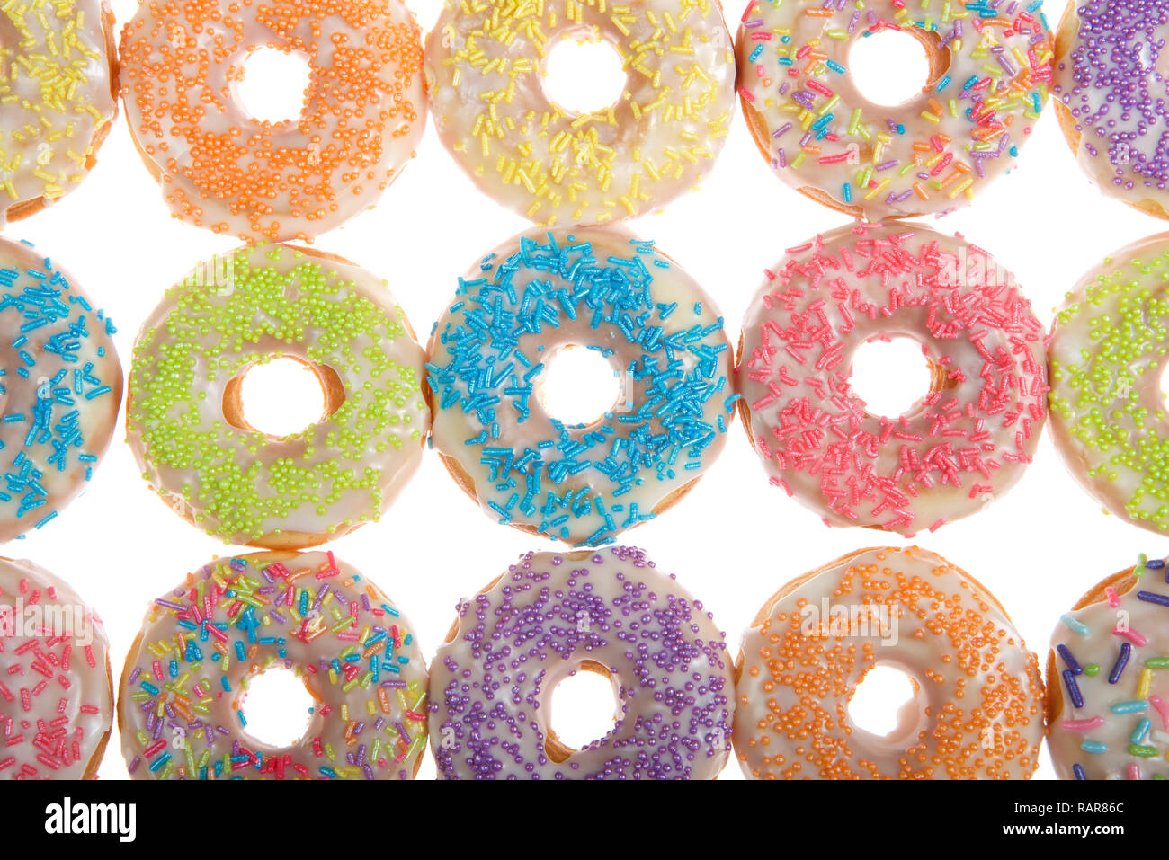 Flach Ansicht vieler Frosted Donuts mit Süßigkeiten besprüht auf Weiß isoliert Stockfoto