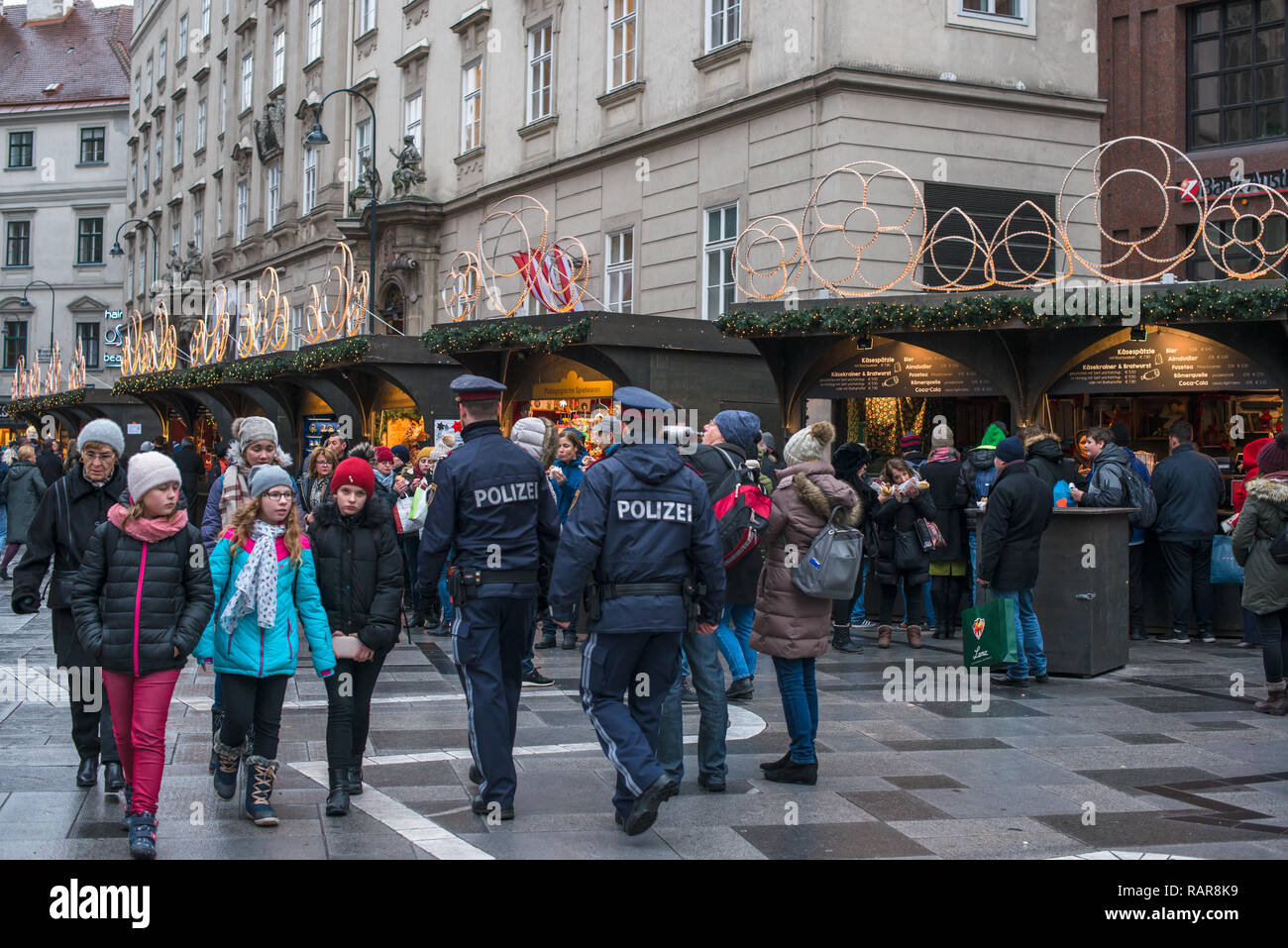 Österreichische Polizei Spaziergang unter den Massen am Weihnachtsmarkt am St. Stephen's Square, Stephansplatz, Wien, Österreich. Stockfoto