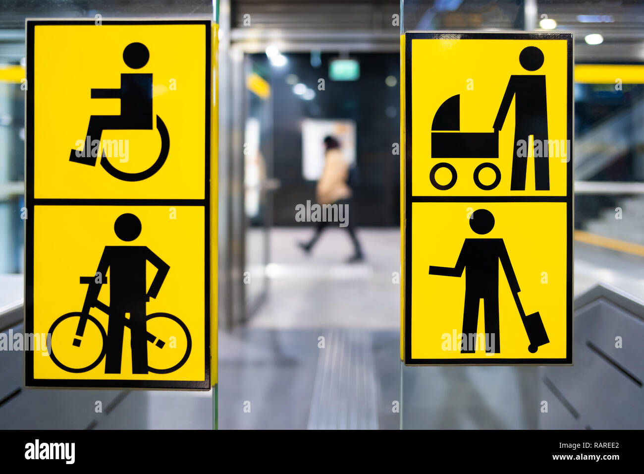 Behinderte, Fahrrad, Kinderwagen und großes Gepäck gelb pictrogram in der Metro, in öffentlichen Verkehrsmitteln, verschwommene Person im Hintergrund Stockfoto