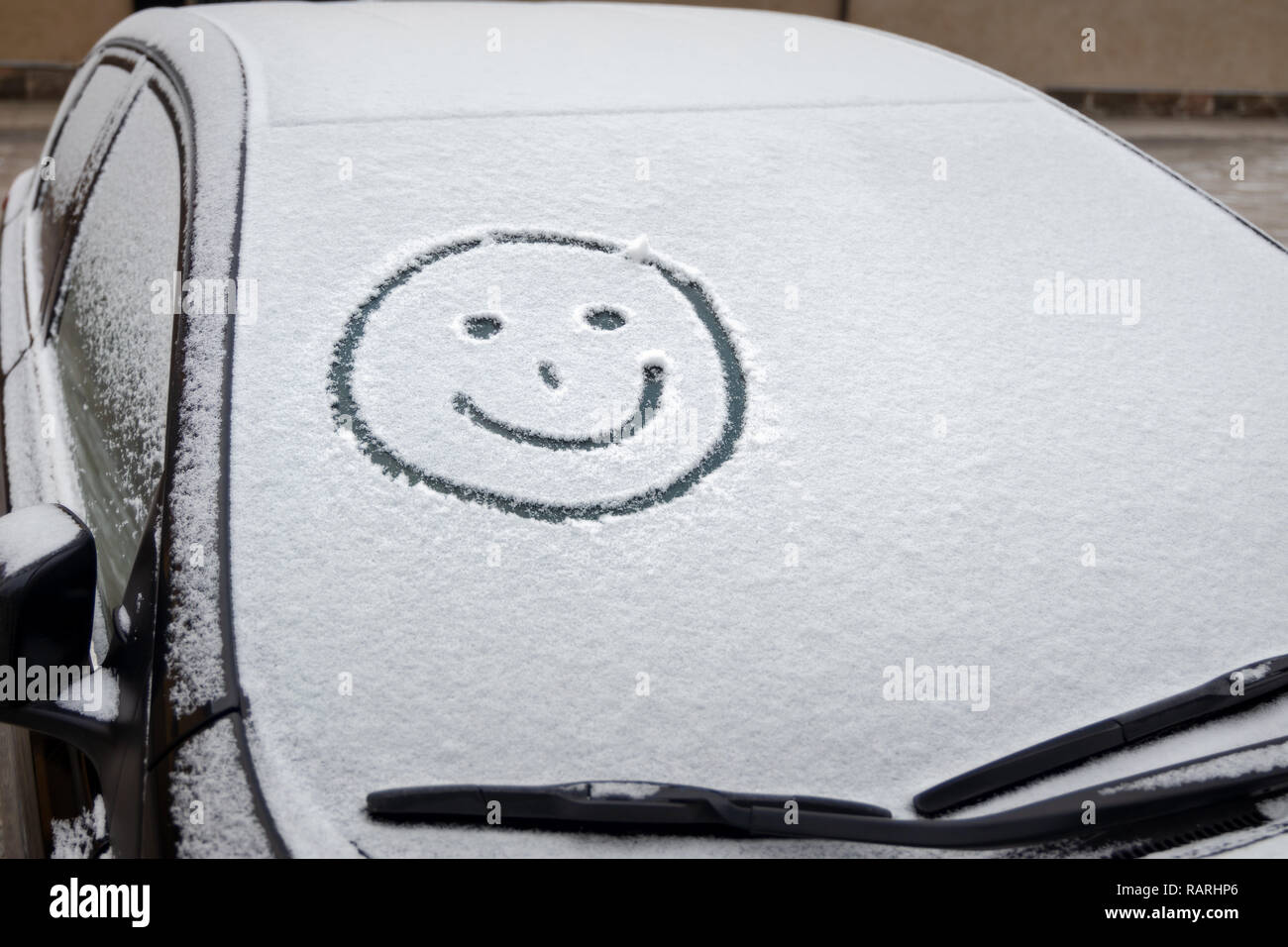 Graffiti im Schnee auf der Windschutzscheibe des Autos Stockfoto