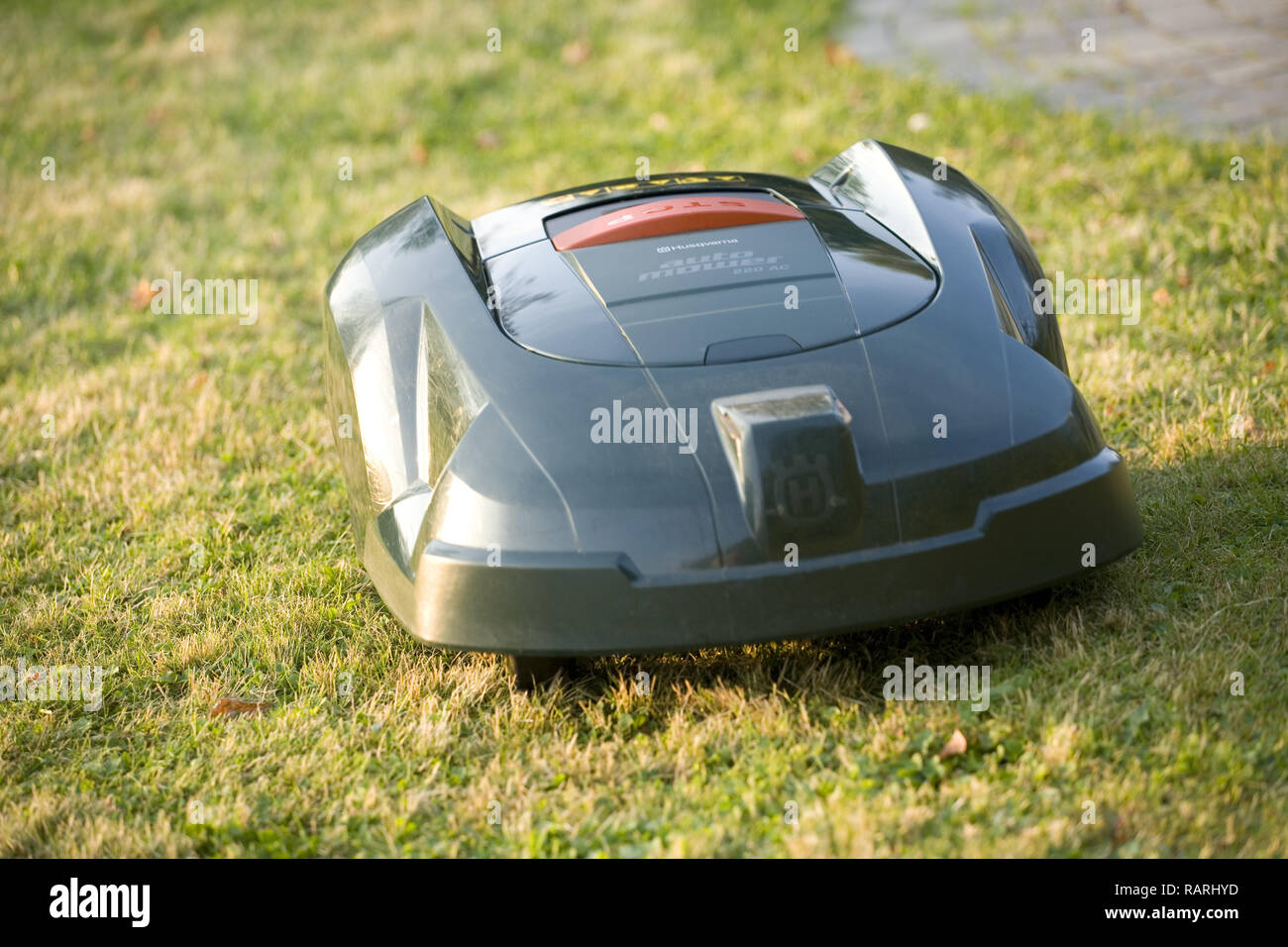 Automatische Roboter Rasenmäher Schneiden von Gras in der Nähe der Überschrift zu Kamera Stockfoto