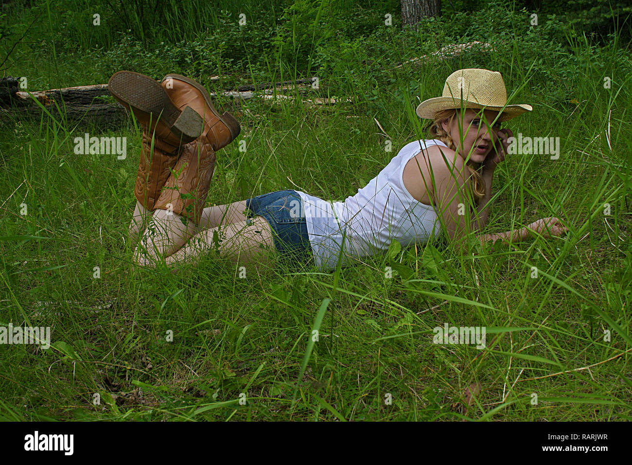 Frau auf dem Bauch und treten Ihre Fersen im Gras Stockfoto