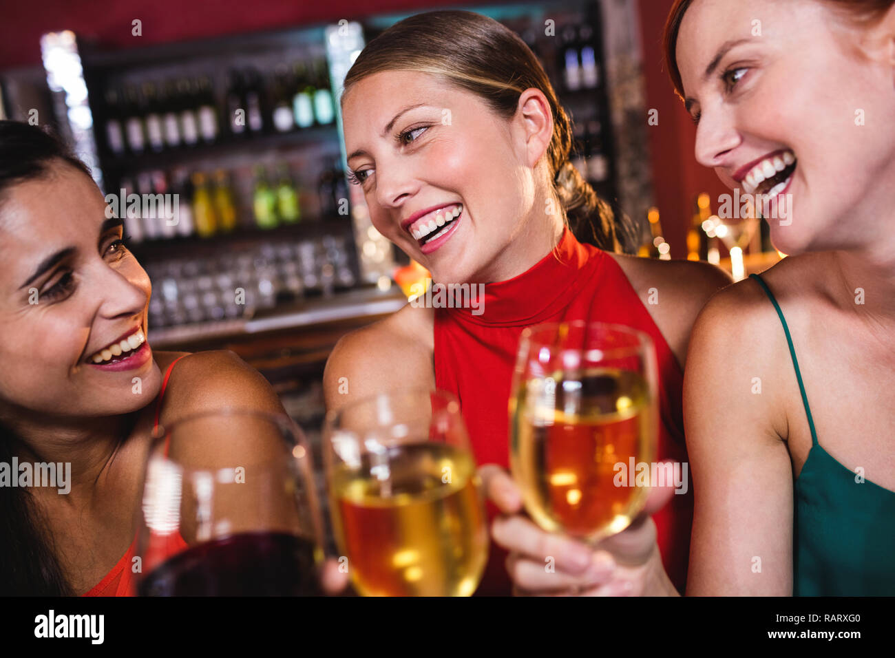 Weibliche Freunde Wein genießen in night club Stockfoto