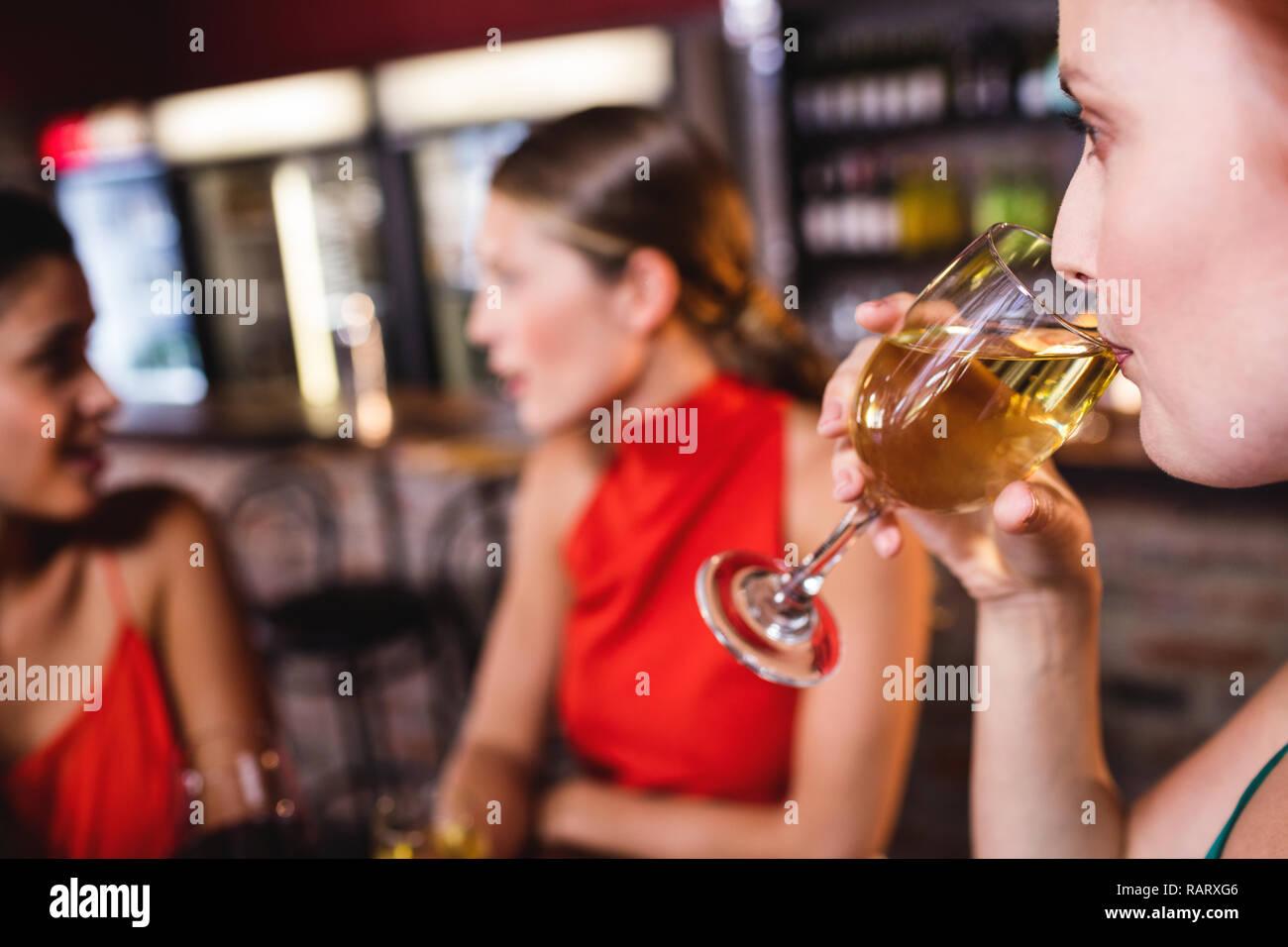 Frau trinkt Weißwein in night club Stockfoto