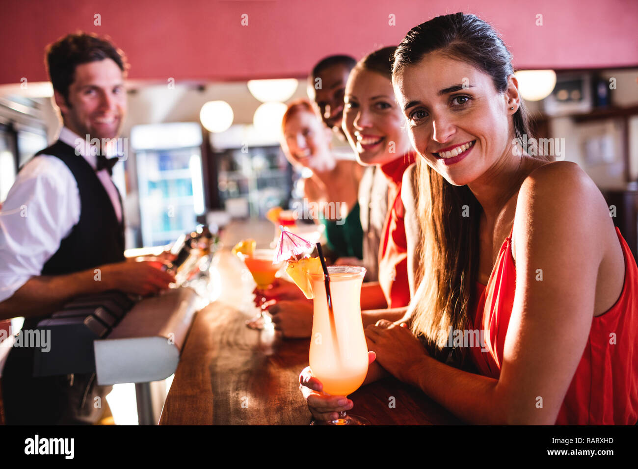 Freunde genießen Getränke am Tresen im Nachtclub Stockfoto