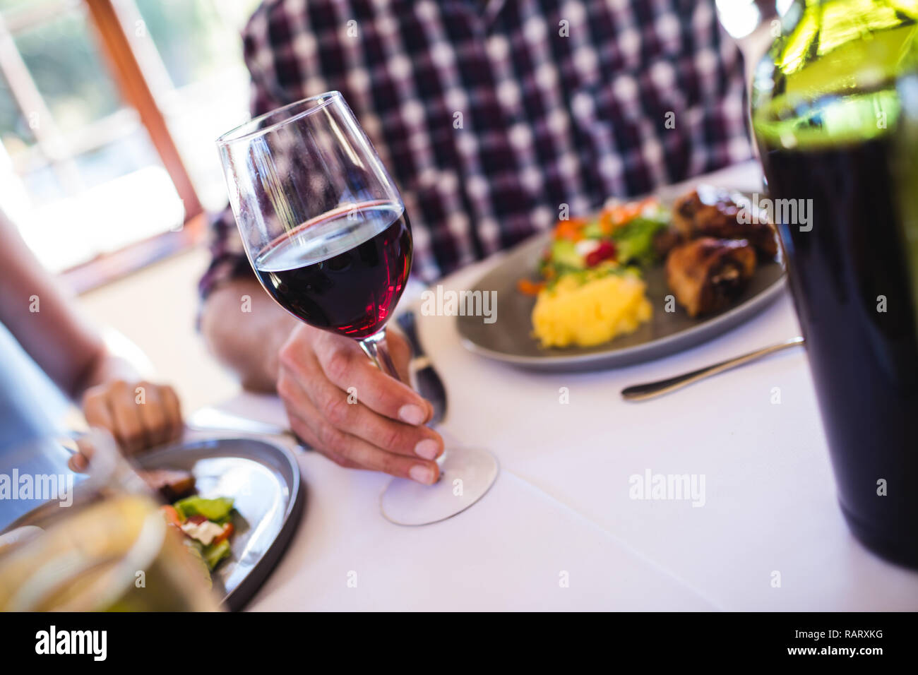 Mann hält Glas Wein im Restaurant Stockfoto