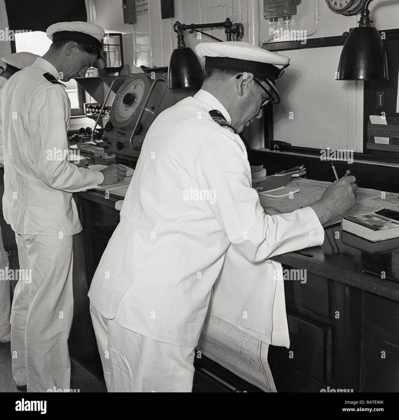 1950, historische, an Bord der Union-Castle Steamship, zwei Uniformierte navigation Offiziere in den Kontrollraum mit Diagrammen arbeiten, die Bewegungen des Schiffes, Position und Richtung verfolgen. Stockfoto