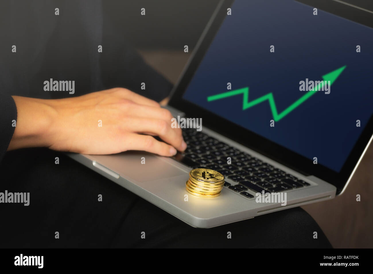 Geschäftsmanns, der auf dem Laptop mit einem goldenen bitcoin Münzen auf it-Stack. Grüne Karte, Preis steigen. Stockfoto