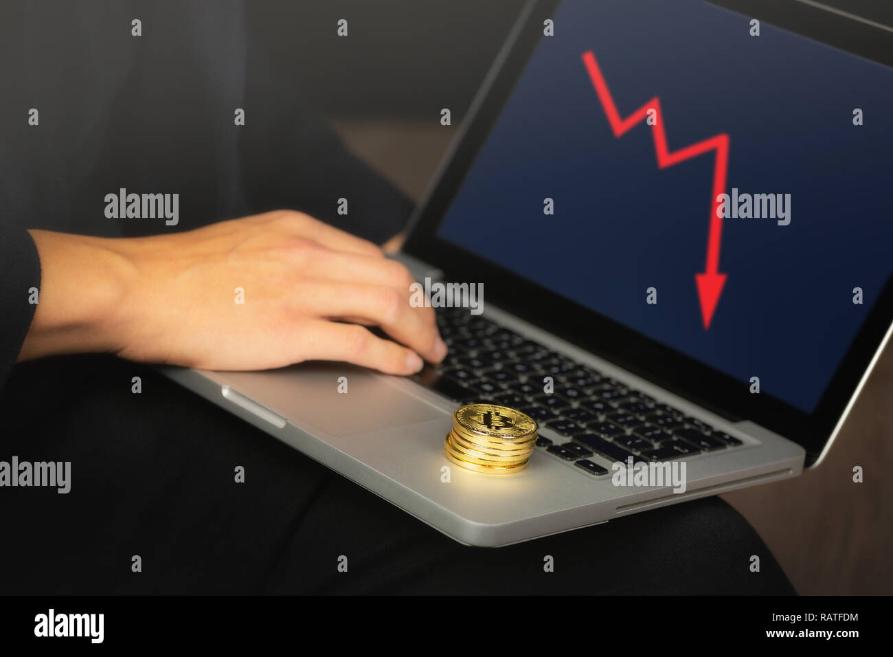 Geschäftsmanns, der auf dem Laptop mit einem goldenen bitcoin Münzen auf it-Stack. Rote Karte, Preis crash Konzept. Stockfoto