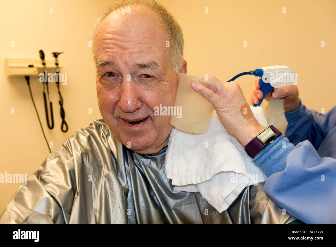"Infamous"-Fotograf Steve Skjold in seine Ohren durch eine Krankenschwester an einer medizinischen Klinik gereinigt. Minneapolis Minnesota MN USA Stockfoto