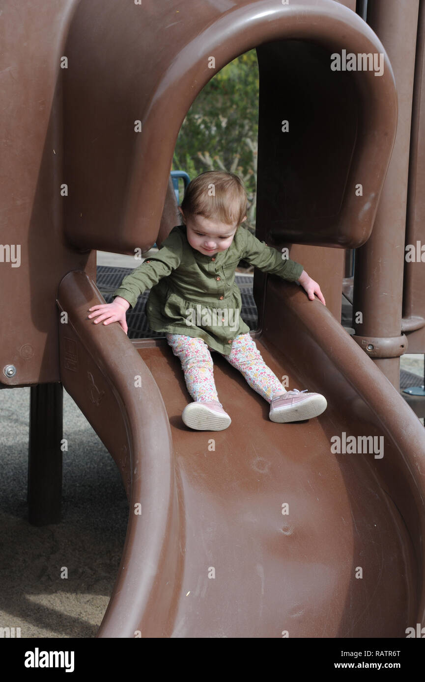Ein Jahr alt auf einer Folie auf einem Spielplatz Stockfoto