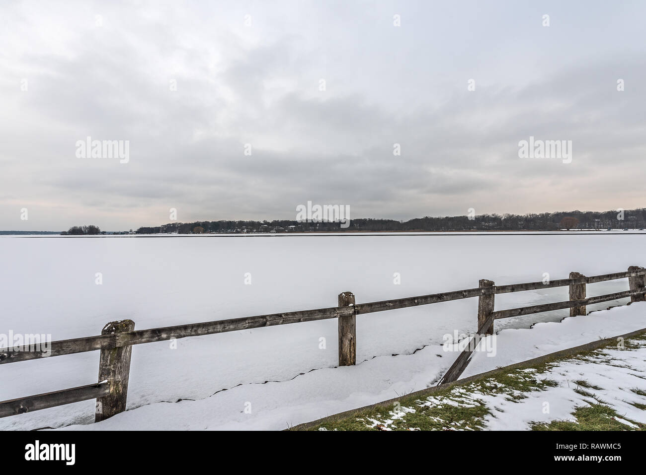 Teilweise zugefrorenen See im Schnee mit grauen Wolken und einem Hauch von rosa oder orange Überdachung Stockfoto