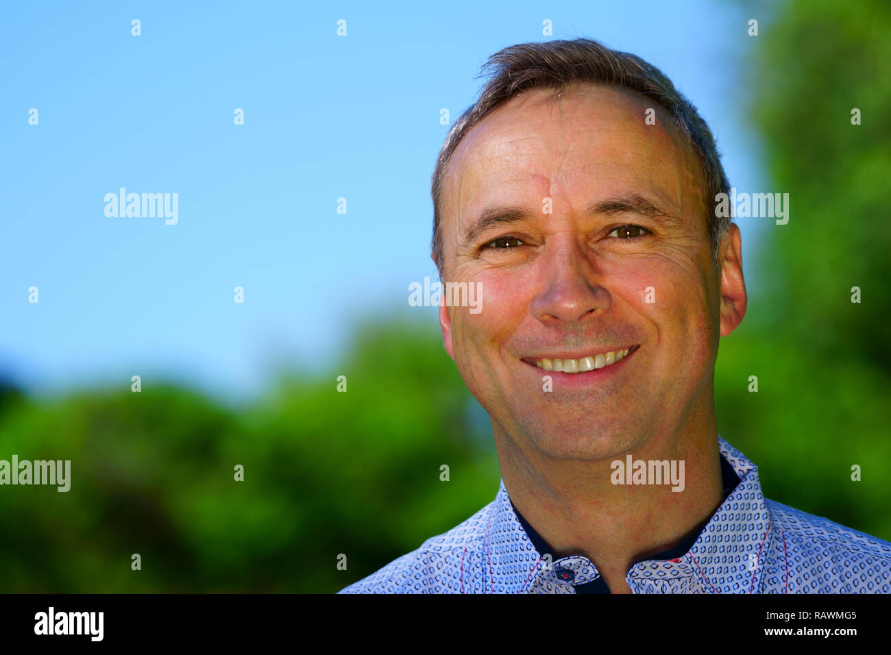 Ein Porträt von einem kaukasischen Mann trägt ein blaues T-Shirt und ein Lächeln in die Kamera. Stockfoto