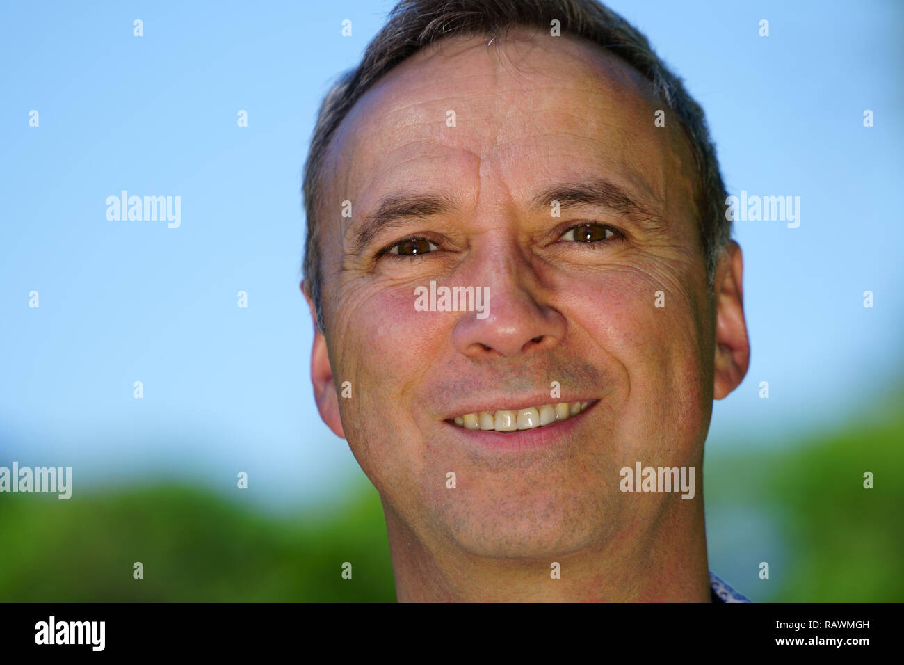 Ein Porträt von einem kaukasischen Mann trägt ein blaues T-Shirt und ein Lächeln in die Kamera. Stockfoto