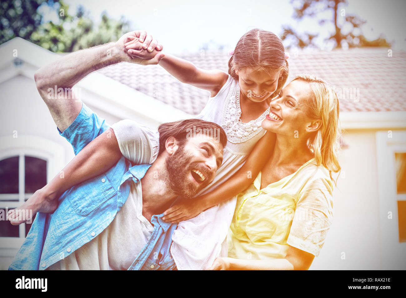 Vater mit Tochter auf Schulter in Hof Stockfoto