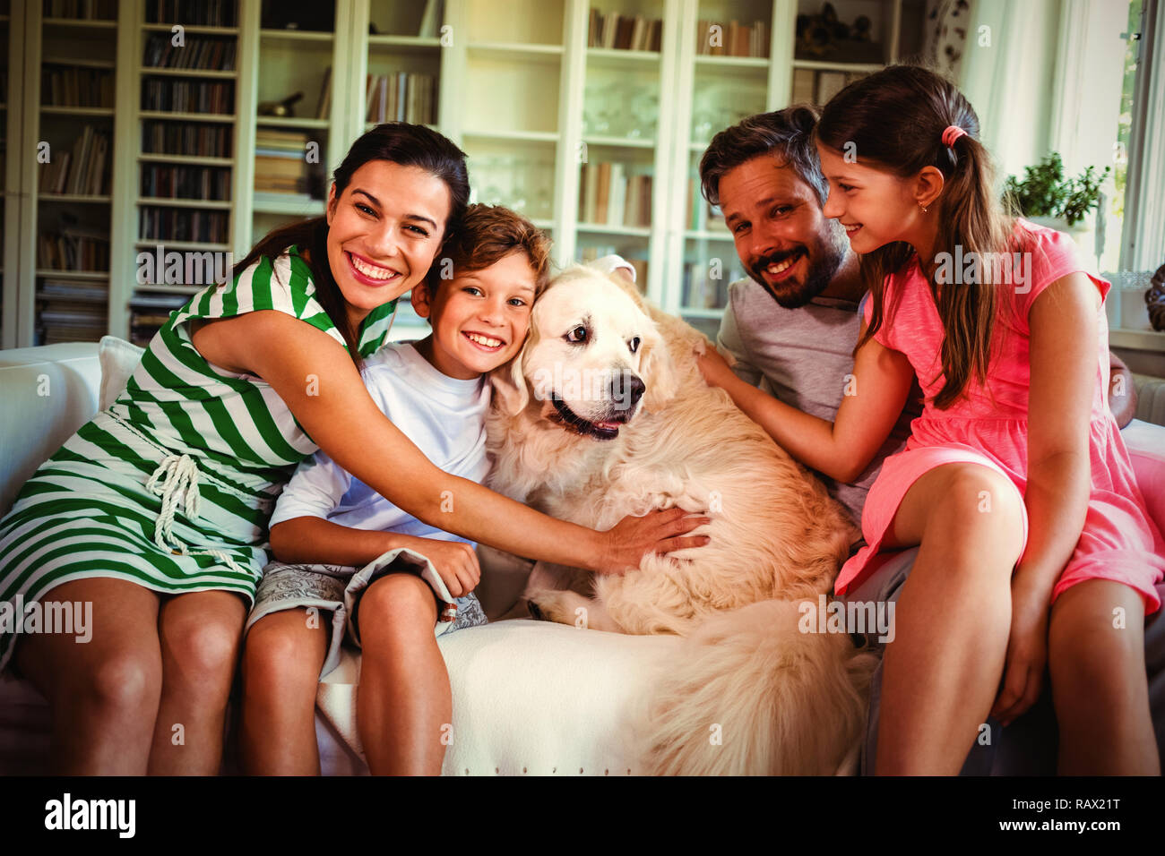 Familie mit Hund sitzt auf einem Sofa im Wohnzimmer. Stockfoto