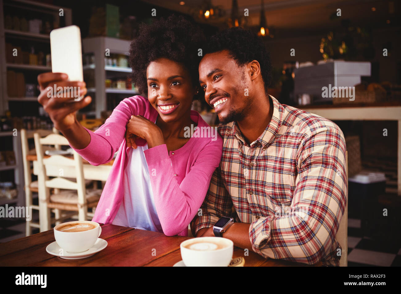 Glückliches junges Paar, die in der Cafeteria selfie Stockfoto