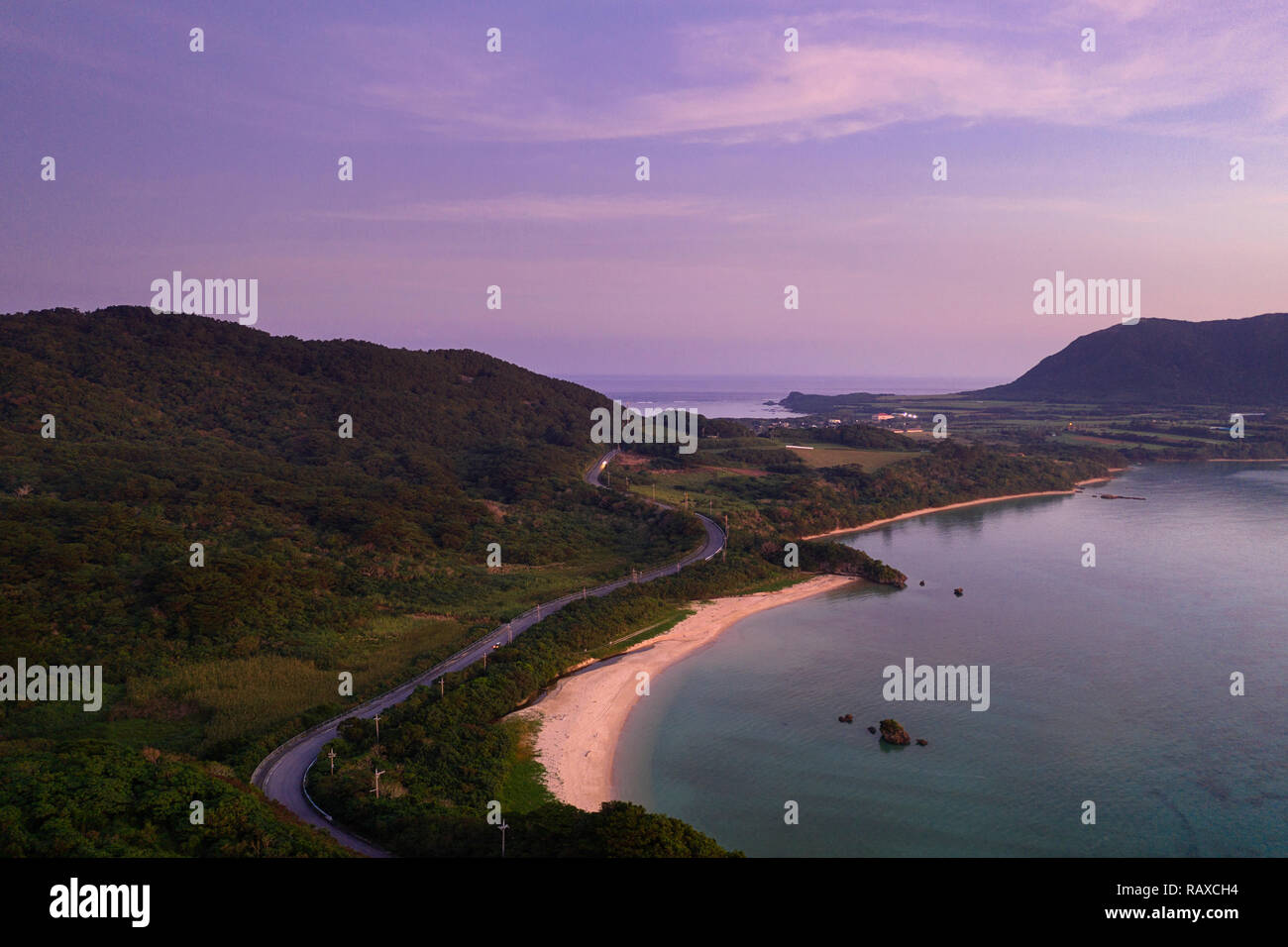 Luftaufnahme über einzigartige tropische Insel mit Berge, einsame weisse Sandstrände und Coral Reef, bei Sonnenuntergang, von Drohne, Ishigaki, Japan Stockfoto