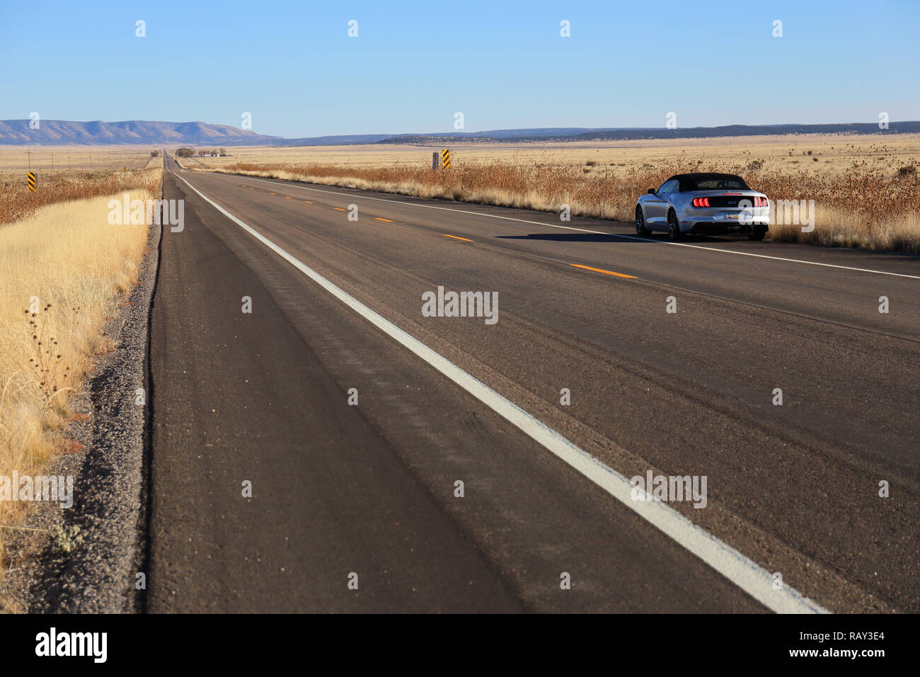 Langer, gerader Strecke von der Straße auf der Route 66 und einer amerikanischen Ford Mustang in den Straßenrand Stockfoto