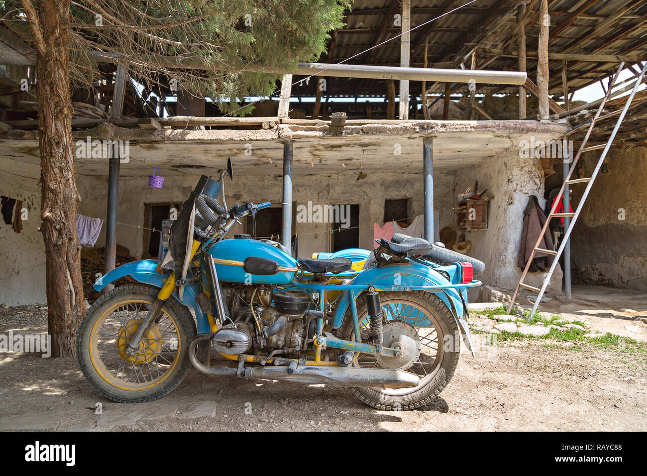 Alte sowjetische blau Motorrad in einem Haus im Dorf, in Areni, Armenien. Stockfoto