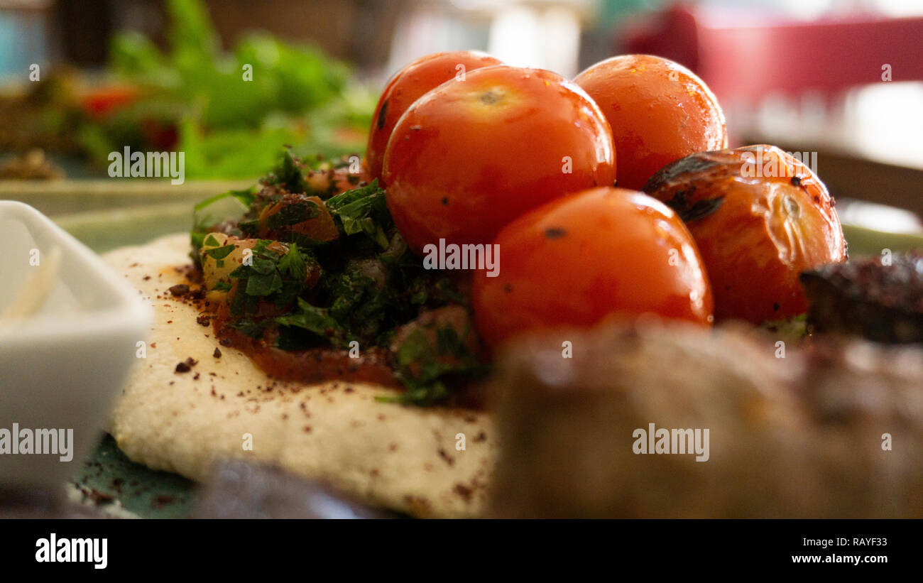 Typische libanesischen Gericht auf Stücke Fleisch basiert gebratene Hackfleisch mit einer Seite der gekochten Tomaten Stockfoto