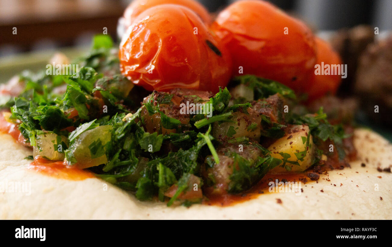 Typische libanesischen Gericht auf Stücke Fleisch basiert gebratene Hackfleisch mit einer Seite der gekochten Tomaten Stockfoto