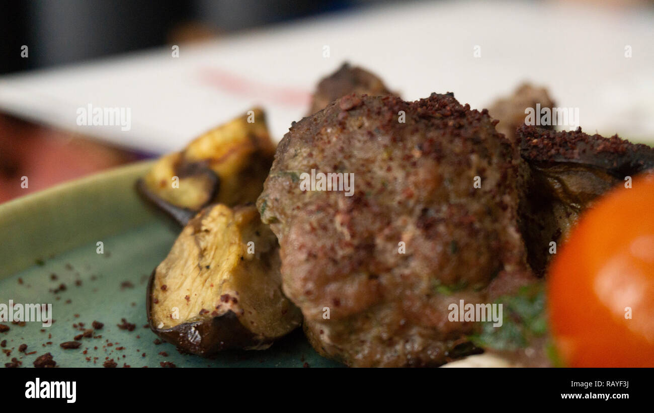 Typische libanesischen Gericht auf Stücke Fleisch basiert gebratene Hackfleisch mit einer Seite der gekochten Tomaten Stockfoto