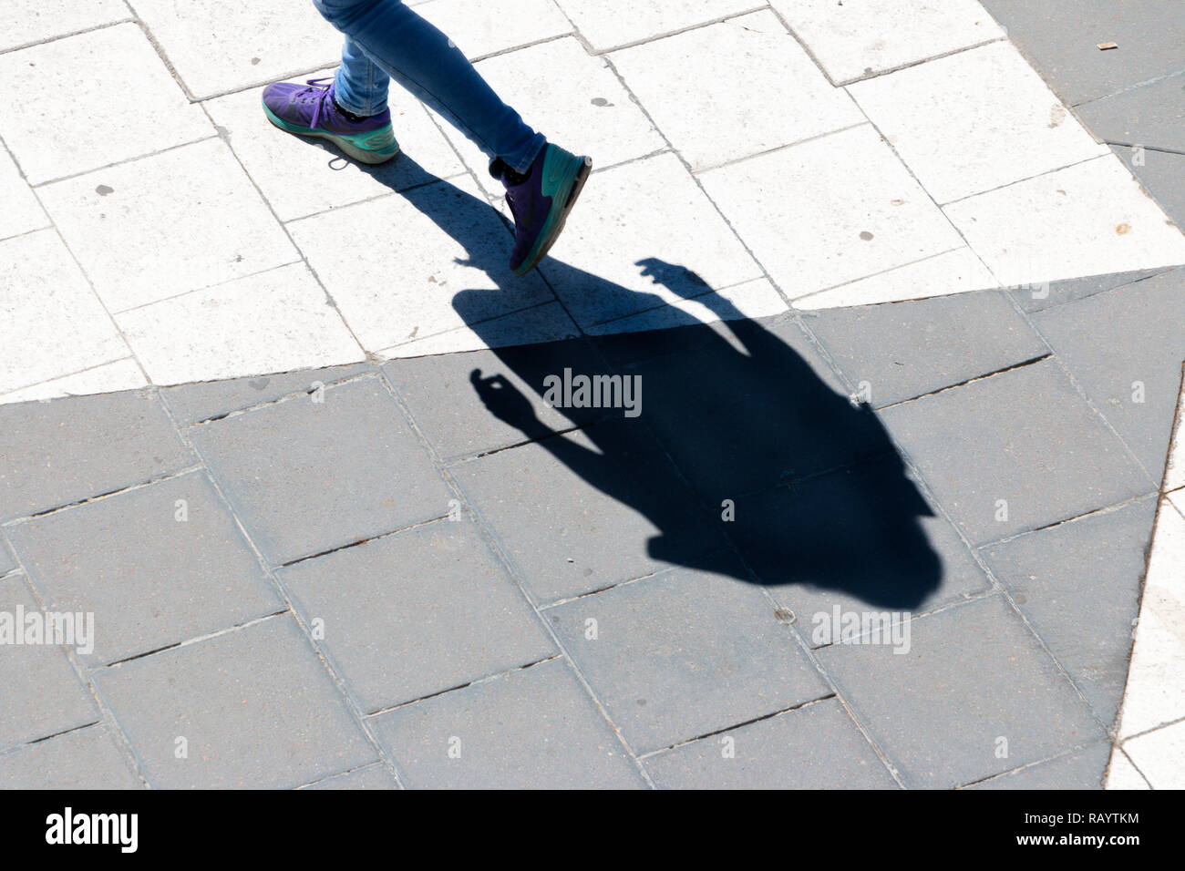 Schatten von Person zu Fuß im Sonnenschein Stockfoto