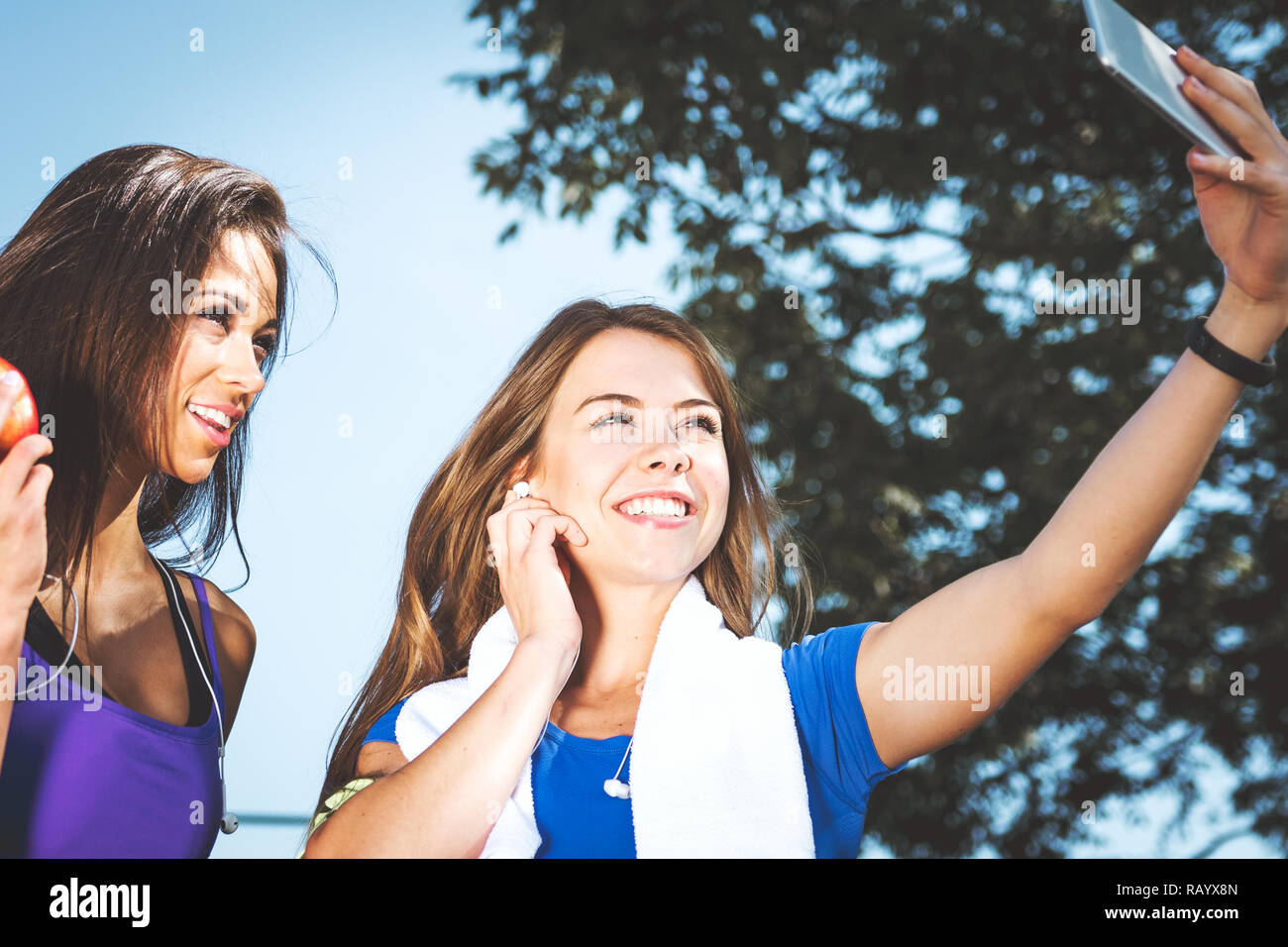 Millennials lifestyle Konzept - zwei Sport Mädchen nehmen eine selfie und Lächeln beim Training im Freien an einem sonnigen Tag (Vintage Effekt) Stockfoto