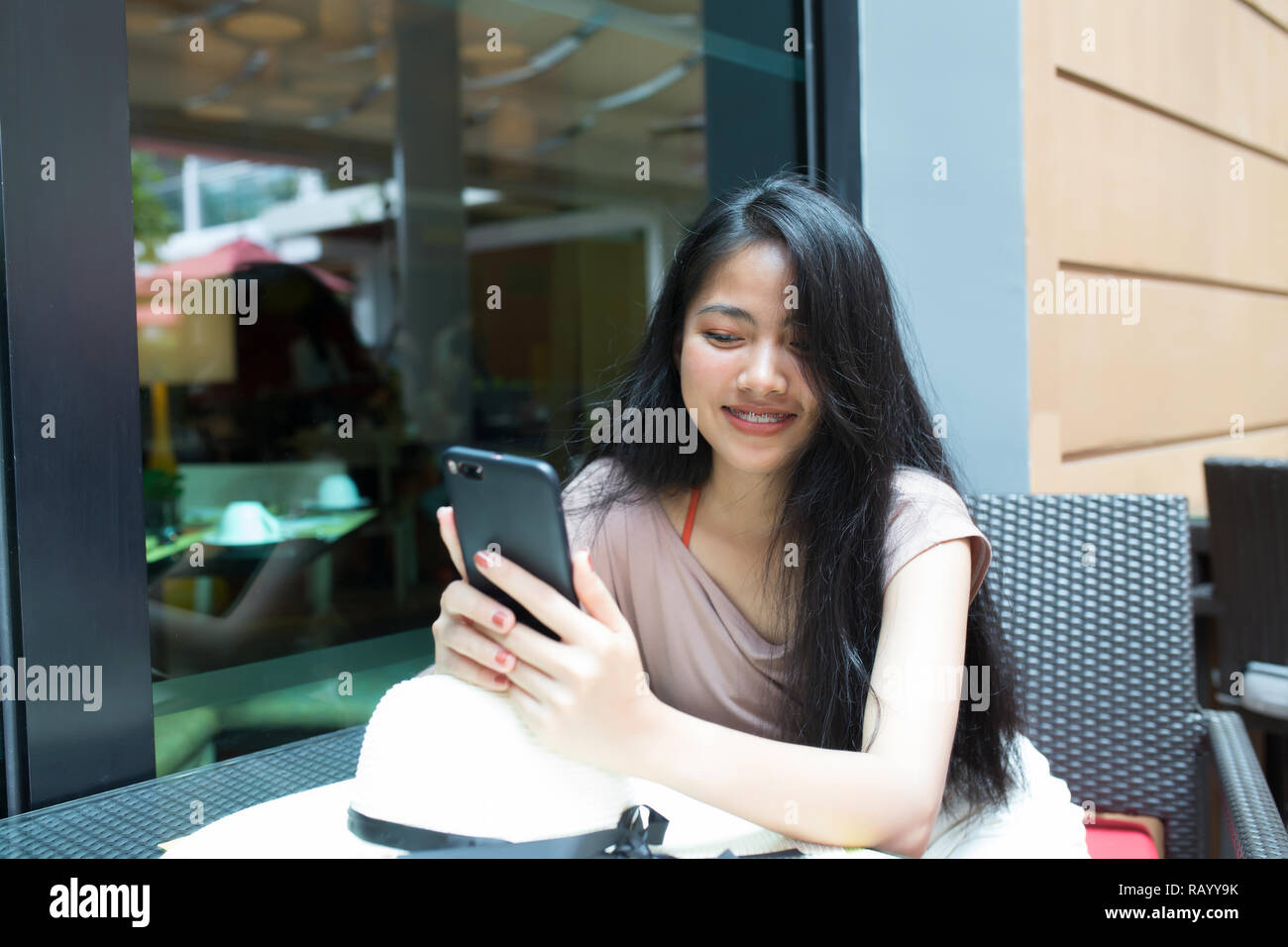 Gerne asiatische Frau mit smart phone in Coffee Shop Stockfoto