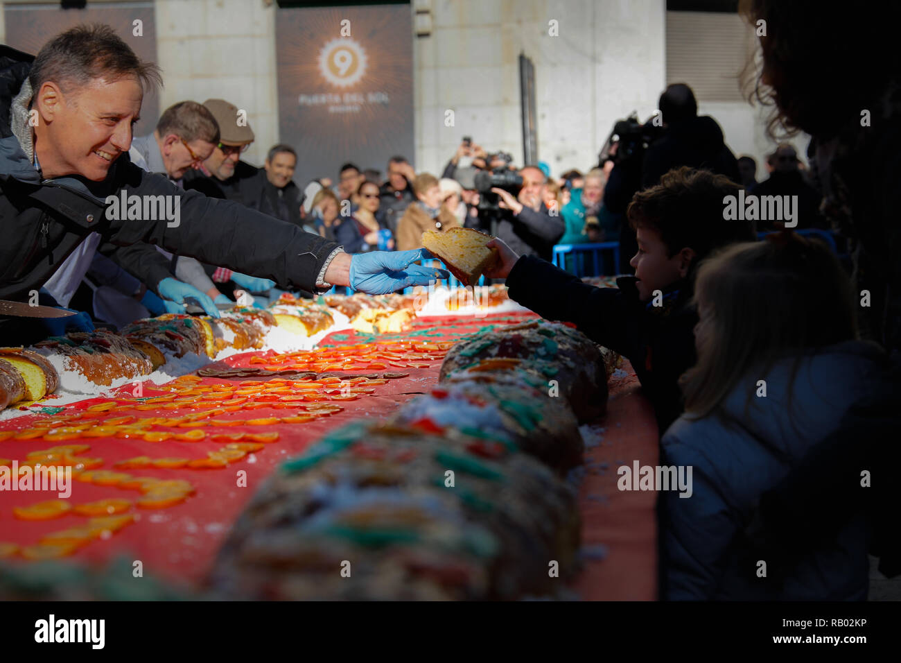 Madrid, Spanien. 5. Januar, 2019. Verteilung der Roscon de Reyes prorations an die Teilnehmer. Die NGO Aldeas Infantiles in Zusammenarbeit mit der Stadtverwaltung von Madrid feiert ein weiteres Jahr in der gedrängten Puerta del Sol Verkostung eine große Roscón de Reyes (runde Kuchen der drei Weisen). Ein Ereignis, das Bewusstsein in der Bevölkerung für die Bedeutung des Genießens Familie Momente wirft, so dass die Kinder wachsen auf Jan 5, 2019 in Madrid, Spanien Quelle: Jesús Hellin/Alamy leben Nachrichten Stockfoto