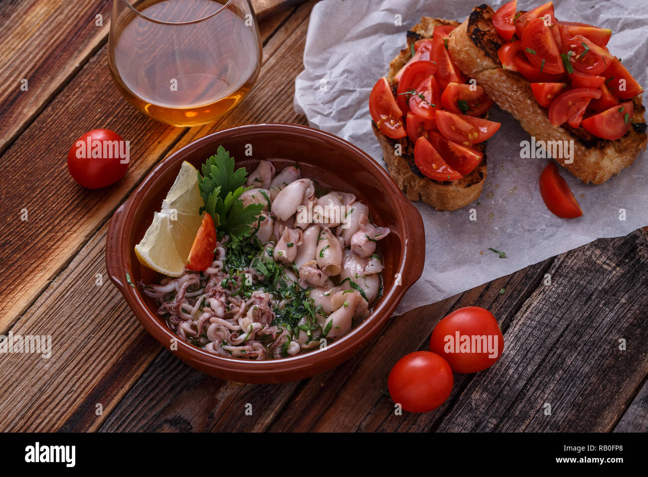 Kleinen Tintenfischen mit Bruschetta und Wein, Ansicht von oben. Stockfoto
