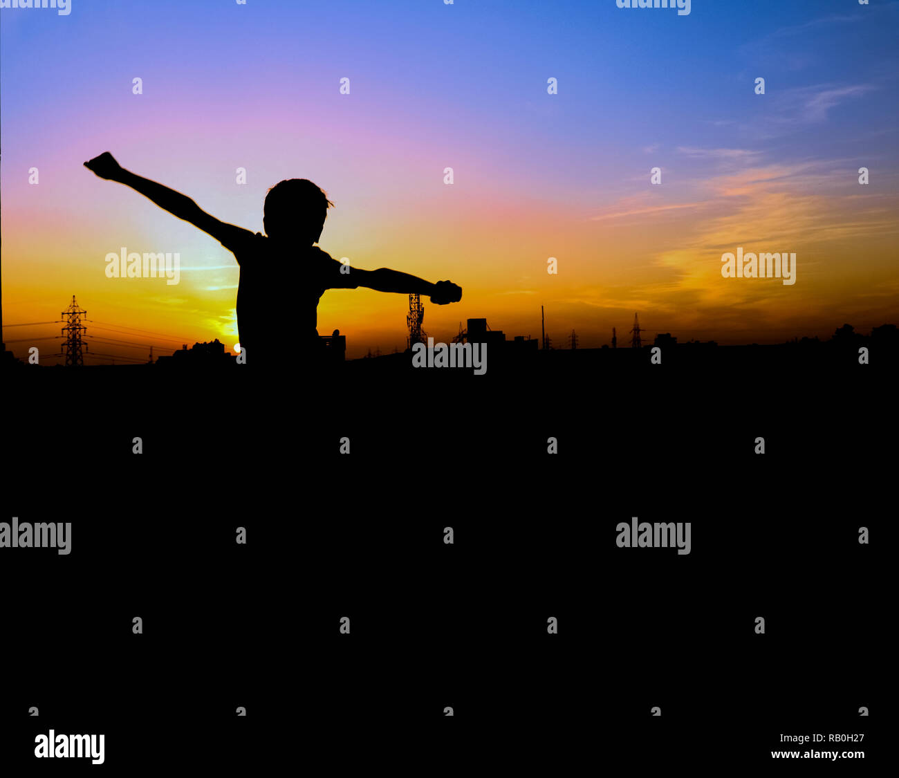 Happy Boy freudigen springen, bei Sonnenuntergang mal spielen, gemütlich Glück verspielte Silhouette. Stockfoto