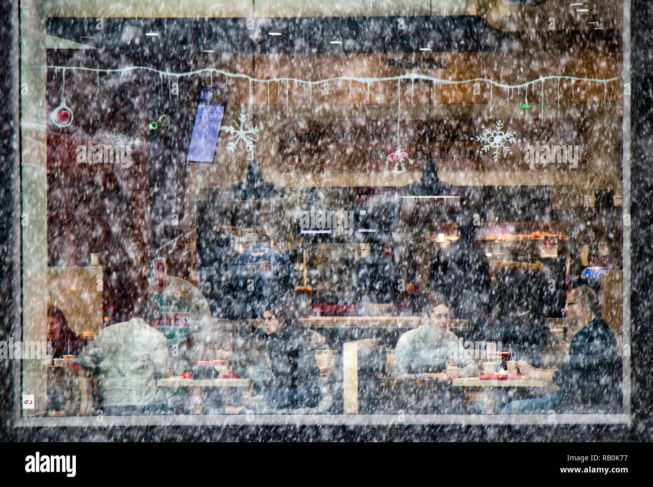 Belgrad, Serbien - Dezember 15, 2018: Die Menschen essen in einem Fast Food Restaurant an einem verschneiten Tag, von außen durch Fenster Glas Stockfoto