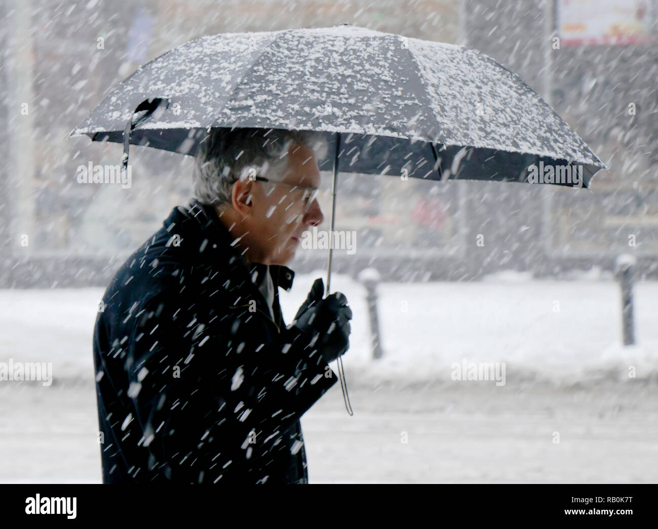 Belgrad, Serbien - Dezember 15, 2018: Ältere Menschen allein zu Fuß unter dem Dach verschneite Stadt Straße in starker Schneefall Stockfoto