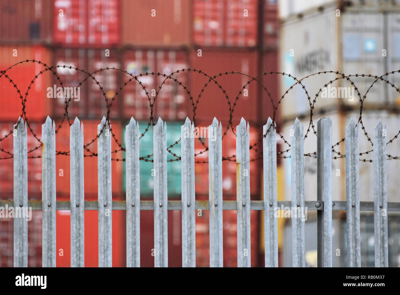 Fracht-/Cargo Container hinter einem Stahl- und Stacheldraht zaun an einem der Seehäfen in Großbritannien. Southampton, Großbritannien. Januar 2019 Stockfoto