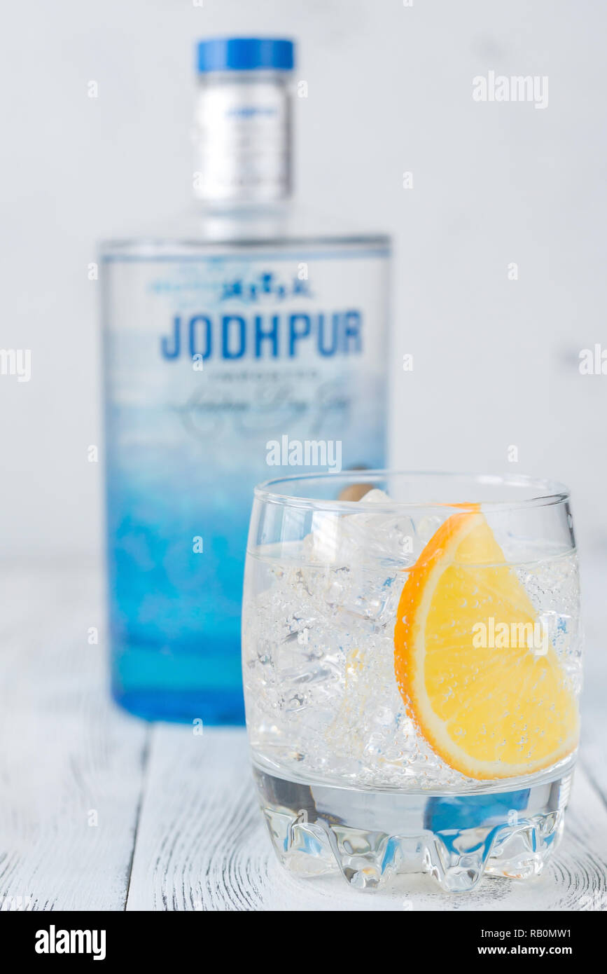 Kharkov, Ukraine - Januar 4, 2019: Glas Gin und Tonic Cocktail mit Flasche Jodhpur Gin auf dem weißen Holz- Hintergrund. Stockfoto