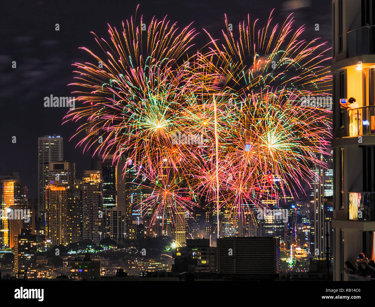 24.00 Uhr Neue Jahr Feuerwerk in Sydney CBD beobachtete, von den Balkonen der hohen Wolkenkratzer Wohnblocks durch regelmäßige Leute genießen Feier eine Stockfoto